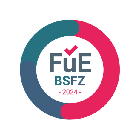 Kreisförmiges Logo mit blauen und rosa Segmenten, Text „FuE BSFZ 2024“ in der Mitte und einem roten Häkchen über dem „u“.