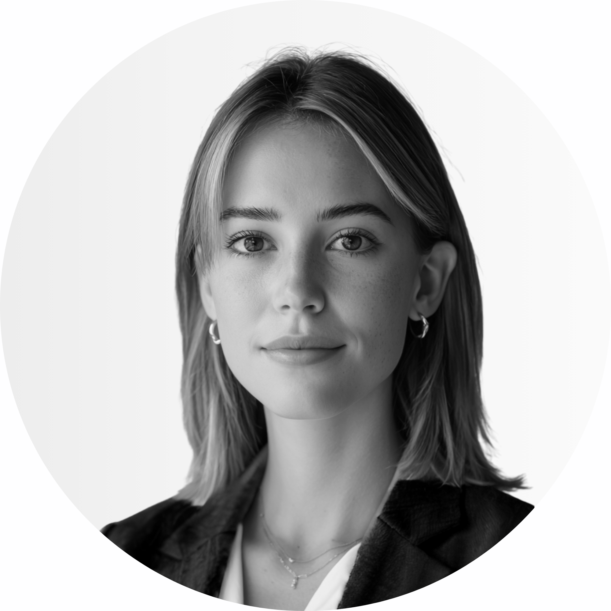 Eine Frau mit blondem Haar, die einen Anzug und Ohrringe trägt.